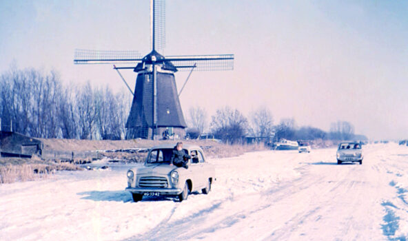 Vijfjarig meisje op de motorkap van de auto van haar grootouders tijdens de Molentocht van 1963 in Kinderdijk.